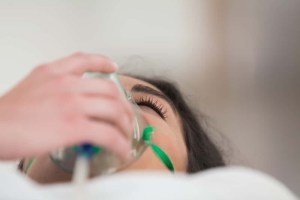 Patient with oxygen mask in hospital ward