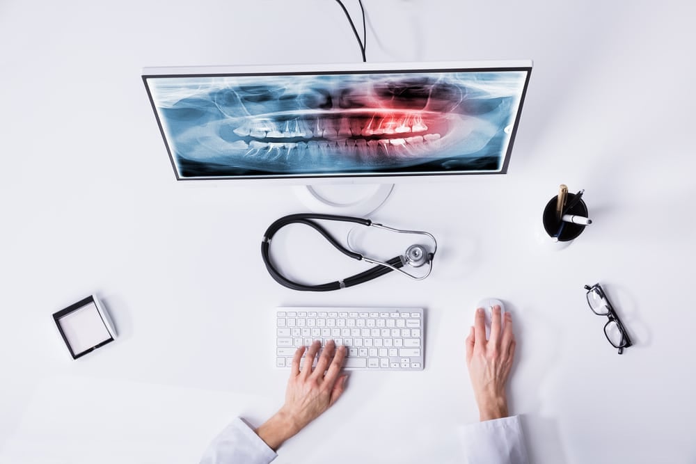 Dentist's Hand Examining Teeth Xray Cottonwood Heights UT, Oral and Facial Surgery of Utah