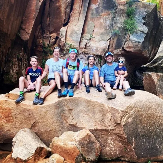 Dr. Partridge with his family sitting on a large rock